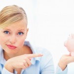 Closeup of woman giving weird smile holding piggybank